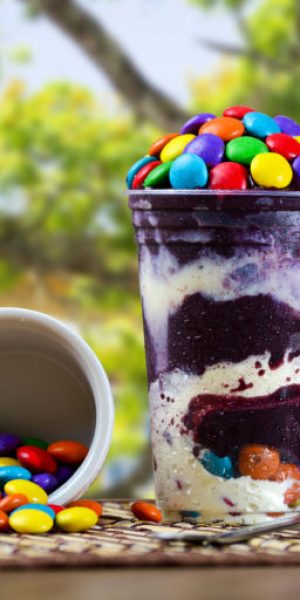 Ice Cream açai Cup with Coated Chocolate Topping, Brazilian Frozen Açai on a purple background